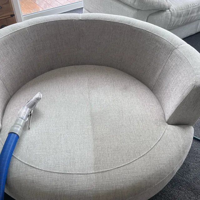 Upholstery cleaning tool on a fabric armchair